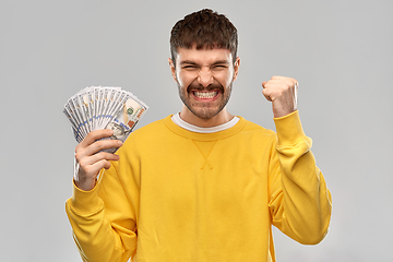 Image showing happy young man with money celebrating success