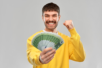 Image showing happy young man with money celebrating success