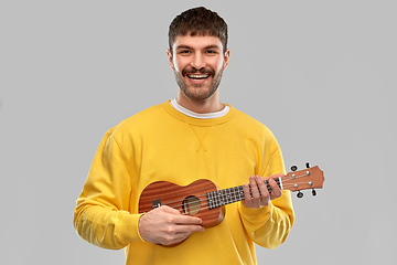 Image showing smiling young man playing ukulele guitar