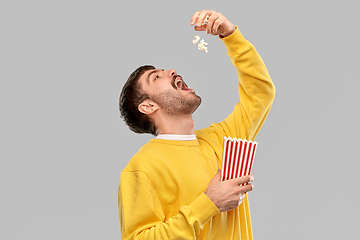 Image showing man in yellow sweatshirt eating popcorn