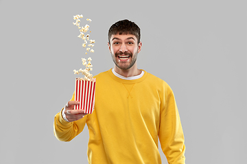 Image showing man in yellow sweatshirt playing with popcorn