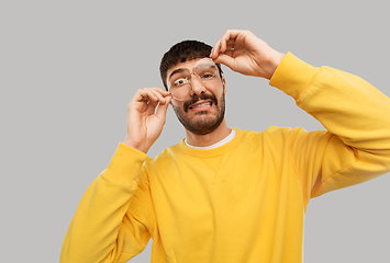 Image showing goofy young man in glasses and yellow sweatshirt