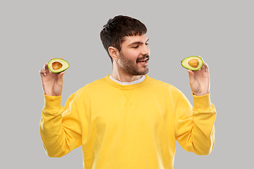 Image showing happy young man in yellow sweatshirt with avocado