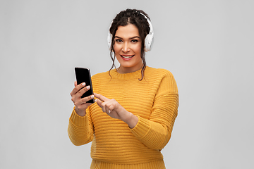 Image showing woman in headphones with smartphone