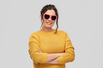 Image showing smiling young woman in heart-shaped sunglasses