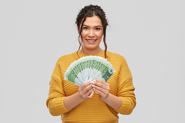 Image showing happy smiling young woman with euro money