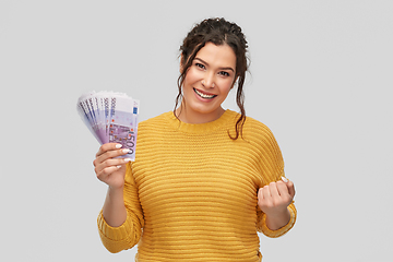 Image showing happy smiling young woman with euro money