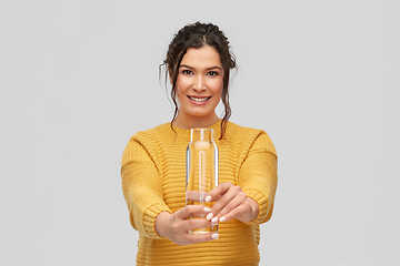 Image showing smiling young woman with water in glass bottle