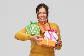 Image showing smiling young woman holding gift boxes