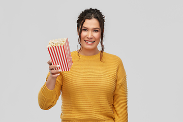 Image showing happy smiling young woman with bucket of popcorn