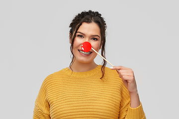 Image showing happy smiling young woman with red clown nose