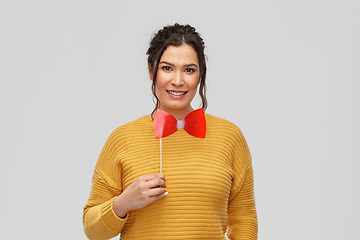 Image showing happy young woman with big red bowtie party prop