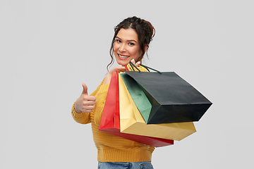 Image showing smiling woman with shopping bags showing thumbs up