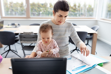 Image showing mother with baby working at home office