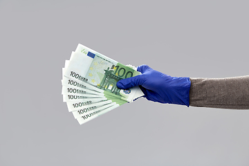 Image showing close up of hand in medical glove with money
