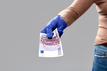 Image showing close up of hand in medical glove with money