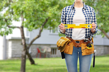 Image showing woman builder with level and working tools on belt