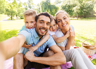 Image showing family having picnic and taking selfie at park