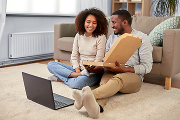 Image showing happy african american couple eating pizza at home