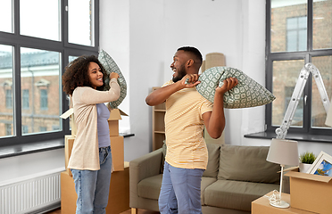 Image showing happy couple having pillow fight at new home