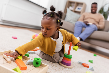 Image showing african baby girl playing with toy blocks at home