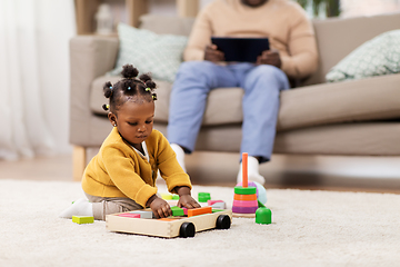 Image showing african baby girl playing with toy blocks at home