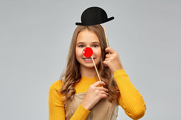 Image showing smiling teenage girl with red clown nose and hat