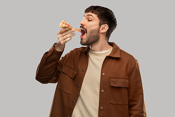 Image showing hungry young man eating pizza