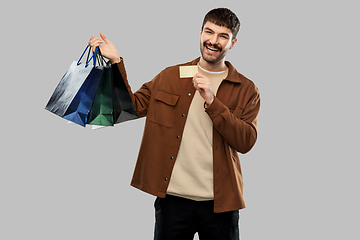 Image showing happy young man with shopping bags and credit card