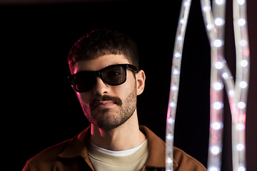 Image showing man in sunglasses over neon lights at nightclub