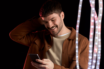 Image showing happy smiling young man with smartphone