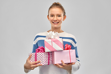 Image showing smiling teenage girl in pullover with gift box