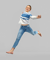 Image showing smiling teenage girl in pullover jumping