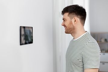 Image showing happy man looking at tablet computer at smart home