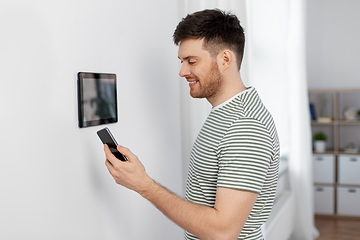 Image showing smiling man using tablet computer at smart home