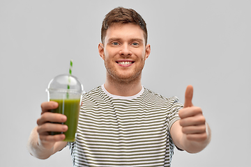 Image showing happy man with green smoothie showing thumbs up