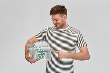 Image showing smiling young man sorting metallic waste