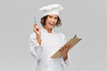 Image showing smiling female chef in toque with clipboard