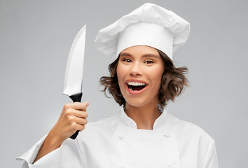 Image showing smiling female chef in toque with kitchen knife