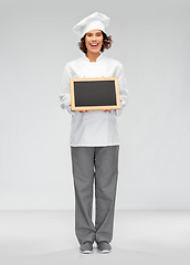 Image showing smiling female chef holding black chalkboard