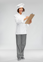 Image showing smiling female chef in toque with clipboard