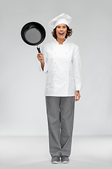 Image showing smiling female chef in toque with frying pan