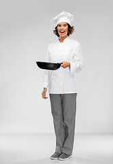 Image showing smiling female chef in toque with frying pan