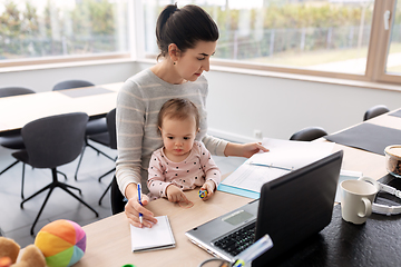 Image showing mother with baby working at home office