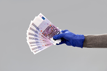 Image showing close up of hand in medical glove with money