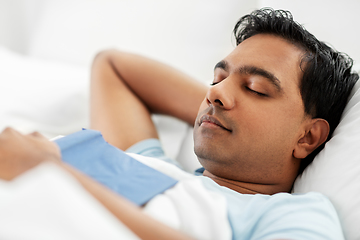 Image showing indian man with book sleeping in bed at home