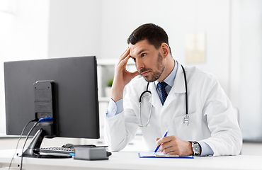 Image showing doctor with clipboard and computer at hospital