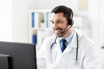 Image showing happy doctor with computer and headset at hospital