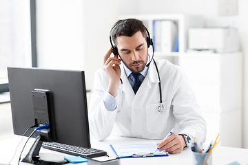 Image showing male doctor with headset and clipboard at hospital