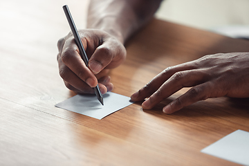 Image showing Close up of african-american male hands, working in office